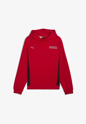 Sarkans hūdijs ar melniem sānu paneļiem, ar kapuci un aukliņām, ribotām aprocēm un sudraba krāsā "SCUDERIA FERRARI" logotipu. Izgatavots no mīkstas auduma.