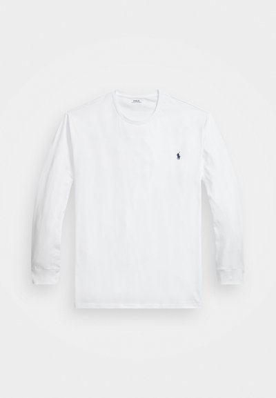 Balta garām piedurknēm izgatavota krekls no mīksta kokvilnas, ar ribotu apkakli, pieguļošiem manžetēm un mazu tumši zilu logo uz krūtīm.