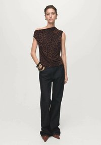 Leopard-print top with an asymmetric neckline, paired with black wide-leg pants. Accessories include multiple bangles and pointed-toe shoes.