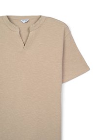 T-shirt beige a maniche corte con scollo a V, realizzato in tessuto testurizzato e con vestibilità comoda. Etichetta con la scritta "CALLIOPE."
