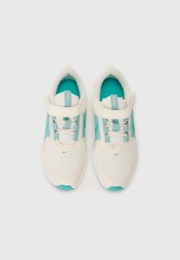 Baskets pour enfants Nike blanches et turquoise avec des tiges en maille, des sangles Velcro et des lacets, vues de dessus sur un fond blanc.