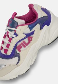 Sneaker bi-materiale bianco con accenti viola e rosa, sovrapposizioni testurizzate e una suola spessa con un logo laterale del marchio.