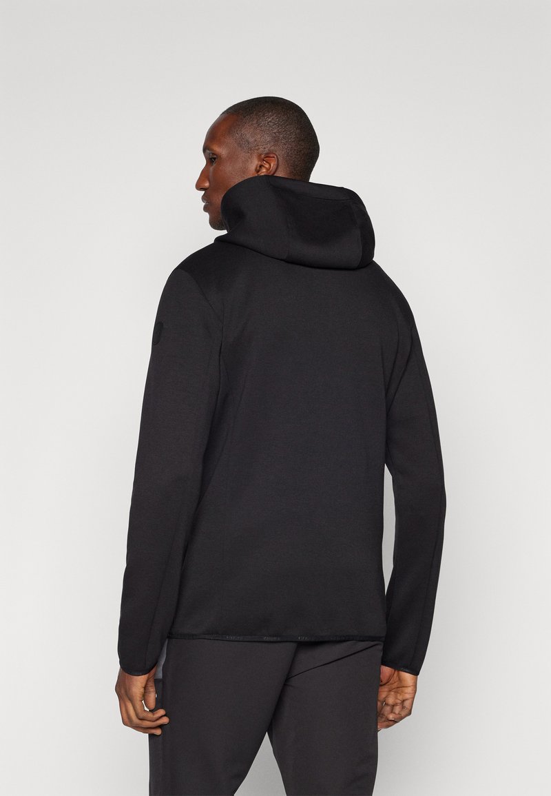 Zwarte capuchontrui met een zachte textuur en lange mouwen. Heeft een relaxte pasvorm en subtiele schouderdetails.