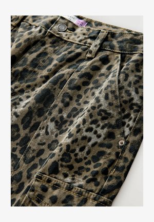 Leopardenmuster-Denimstoff in Beige- und Schwarztönen, mit kontrastierenden Nähten und metallischen Knopfakzenten. Auffälliges Detail der vorderen Tasche.