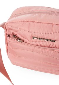 Bolso sintético rosa con textura acolchada horizontal, cuenta con un cierre metálico y el logo "SKECHERS" en plata en la parte delantera.