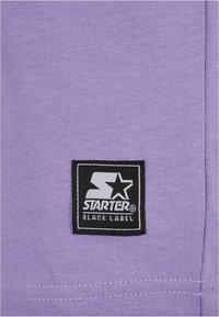 Purple cotton fabric with a textured finish, featuring a black square logo patch that reads "STARTER BLACK LABEL" in white lettering.