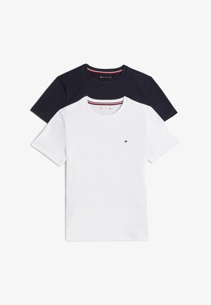 Deux t-shirts unis à col rond, un blanc devant et un noir derrière, tous deux ornés d’un petit logo brodé sur la poitrine.