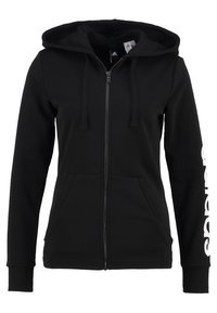 Sweat à capuche zippé noir avec poches avant, capuche à cordon et logo « Adidas » vertical sur la manche droite.