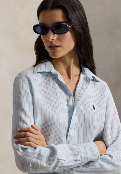 Ανοιχτό μπλε ριγέ πουκάμισο με κουμπιά από λινό, με γιακά, μακριά μανίκια και μικρό κεντημένο λογότυπο στο στήθος.