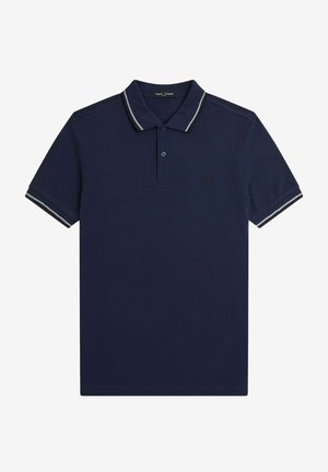 Camisa polo de color azul marino hecha de algodón, con un cuello clásico, tapeta de dos botones y rayas blancas contrastantes en el cuello y las mangas.