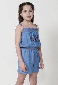 Denim šortai su elastinga juosmens dalimi, išsiuvinėtas gėlių dizainas mėlyna ir raudona spalvomis, reguliuojamos petnešos su spalvingais karoliukais. Šviesiai mėlyna spalva, laisvas siluetas.