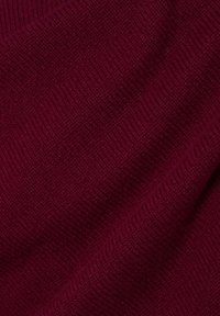 Burgundská pletenina s texturovaným vzorem, která se vyznačuje rýhami a jemným, teplým vzhledem.
