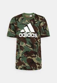 Groene en bruine camouflage t-shirt van katoen, met een groot wit Adidas-logo aan de voorkant en een ronde hals.