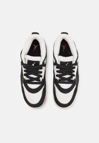 Mustat ja valkoiset tennarit, joissa on mokka- ja verkkomateriaali, mustat nauhat, pehmustettu nilkkaosa sekä punainen logo kielekkeessä ja sisävuorissa.