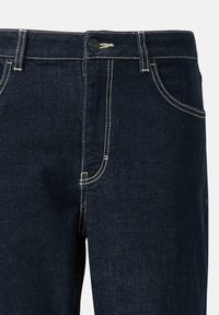 Jeans in denim blu scuro con una texture liscia, caratterizzati da cuciture gialle in contrasto e una chiusura con bottone in vita.