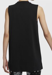 Svart ärmlös topp med hög halsringning och en avslappnad passform. Tillverkad av ett mjukt tyg, har sidospår och en rak fåll.