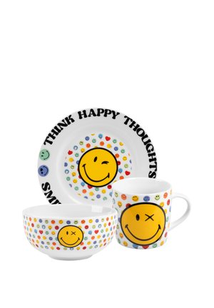 White plate, bowl, and mug each decorated with colorful small smiley faces and a large yellow winking smiley, plate reads "Think Happy Thoughts."