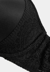 Sujeta con encaje negro y detalles florales transparentes, tela de textura suave y banda lisa. Presenta patrones de encaje intrincados y una forma sin costuras.