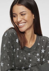 Dark gray sweater with a round neck, featuring a star pattern in light gray. Soft texture, long sleeves, and a relaxed fit.