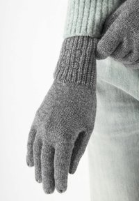 Graue gestrickte Handschuhe mit einem gerippten Bündchen und einem gestickten Schmetterlingsdetail. Der Stoff wirkt weich und warm, ideal für kaltes Wetter.