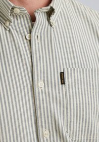 Camisa de botones con Rayas verticales en azul y blanco, que cuenta con un bolsillo, botones blancos y una etiqueta PME Legend en el lateral. Tejido de algodón.