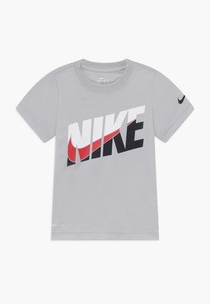 Lichtgrijs Nike Dri-FIT T-shirt met korte mouwen, grote gestileerde NIKE-tekst en rood swoosh-logo op de borst, en een kleine zwarte swoosh op de linkermouw.