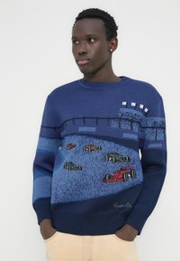 Μπλε σκούρο πλεκτό πουλόβερ με γραφικό αγώνων, με λεπτομερή πολύχρωμα αυτοκινητάκια και υφασμένο σχέδιο στο στήθος και τα μανίκια.