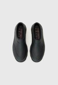 Schwarze Slipper mit einer glatten, matten Oberfläche verfügen über abgerundete Kanten, eine dicke Sohle und ein strukturiertes Innenfutter, das auf den Fußbetten sichtbar ist.