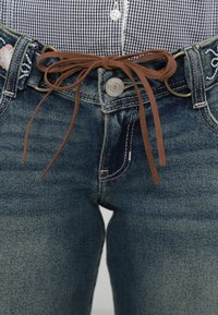 Σκούρο μπλε τζιν παντελόνι με ξεθωριασμένο φινίρισμα, που διαθέτει καφέ δέσιμο με κορδόνια, μεταλλικό κουμπί με την επωνυμία "Hollister" και διακοσμητική ραφή.