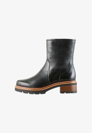 Schwarzer Lederknöchelstiefel mit runder Spitze und feinen Nähten. Verfügt über einen braunen Holzabsatz und eine Gummisohle mit Profil.