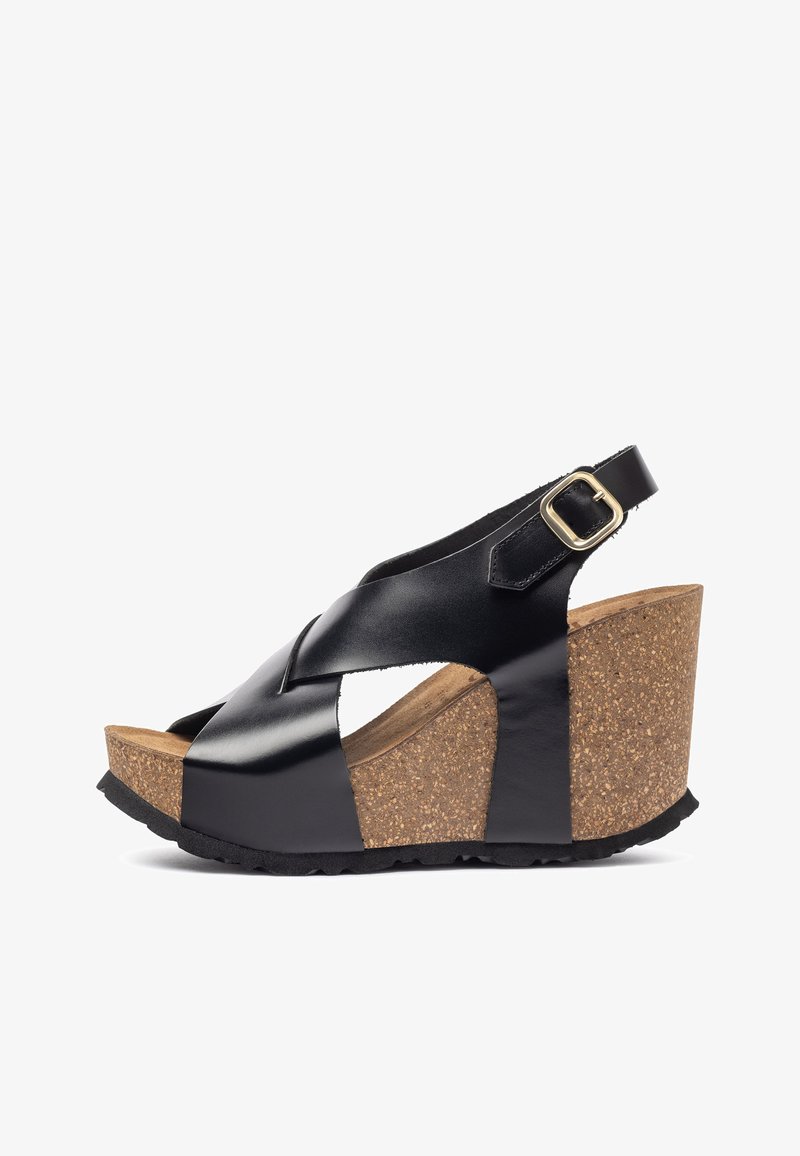 Sandales compensées en cuir noir avec une plateforme en liège, présentant un design entrecroisé et une bride de cheville ajustable avec des accents en métal doré.