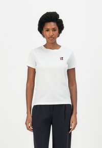 White cotton t-shirt with short sleeves and a round neckline. Features a small maroon "LOVE" graphic on the left chest.