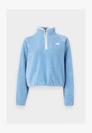 Šviesiai mėlynas flisinis puloveris su ketvirčio užtrauktuku, baltais akcentais ir šoninėmis siūlėmis. Turi ilgomis rankovėmis ir trumpą hemą.