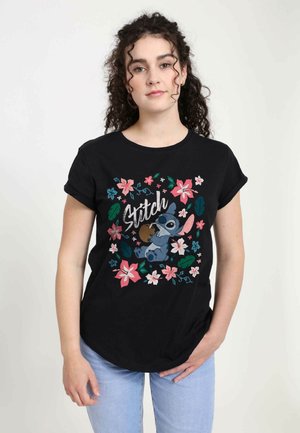 Black cotton t-shirt featuring a graphic of Stitch surrounded by colorful flowers and leaves. The design includes the word "Stitch" in white script.