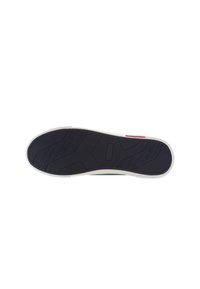 Black rubber shoe sole with textured grip and patterned tread. Features a white outer edge and rectangular accent near the heel.