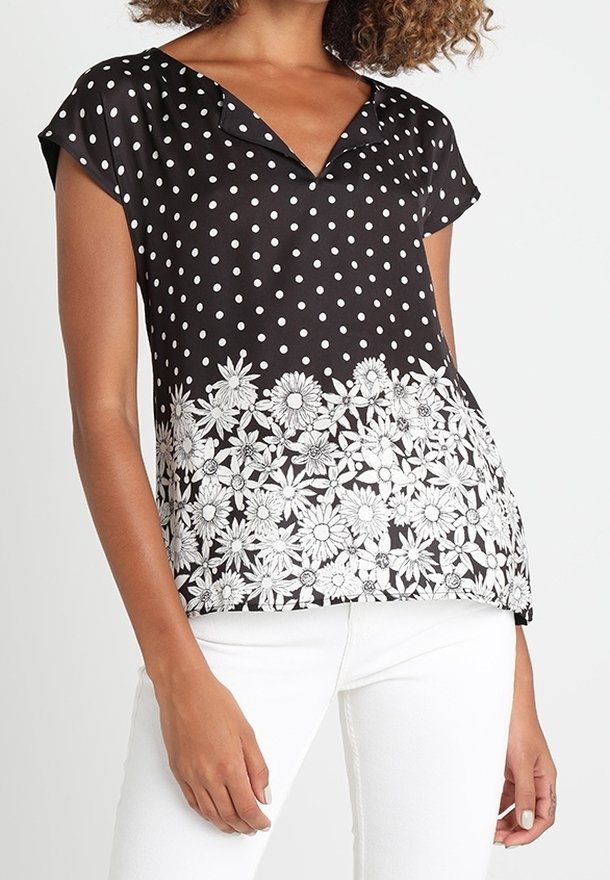 Černé tričko s krátkým rukávem, zdobené bílými puntíky a květinovým vzorem na lemu. Hladká látka s výstřihem do V a krátkými rukávy.
