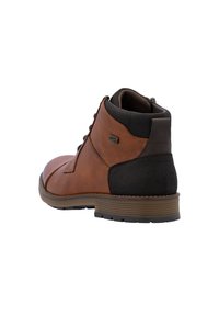 Bottine en cuir marron avec un talon en daim noir mat, à lacets à l'avant et semelle en caoutchouc texturé pour plus de durabilité.