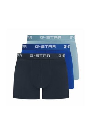 Drie paar G-Star boxers in schakeringen van donker marineblauw, blauw en lichtblauw. Elk met een contrasterende logo tailleband. Zachte stoftextuur.