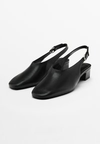 Scarpe in pelle nera con design a punta quadrata, tacco basso a blocco e cinturino alla caviglia regolabile. Textura liscia e accenti minimi.