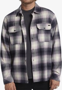 Geruiten shirt in tinten marineblauw en crème, met een knoopsluiting aan de voorkant, twee borstzakken en een ontspannen pasvorm van textuurstof.