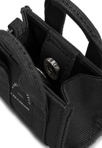 Melna auduma soma ar teksturētu ārpusi, ar magnētiskajām aizdares pogām un redzamu logotipa izdruku sānos.