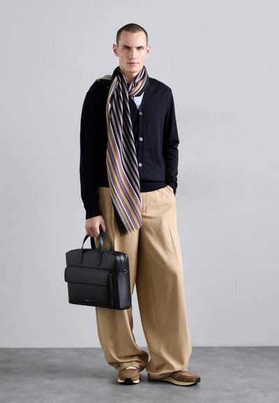 Svart skinnveske, marineblå cardigan, stripete skjerf i grått, gult og lilla, beige vide bukser, brune og kremfargede sko.