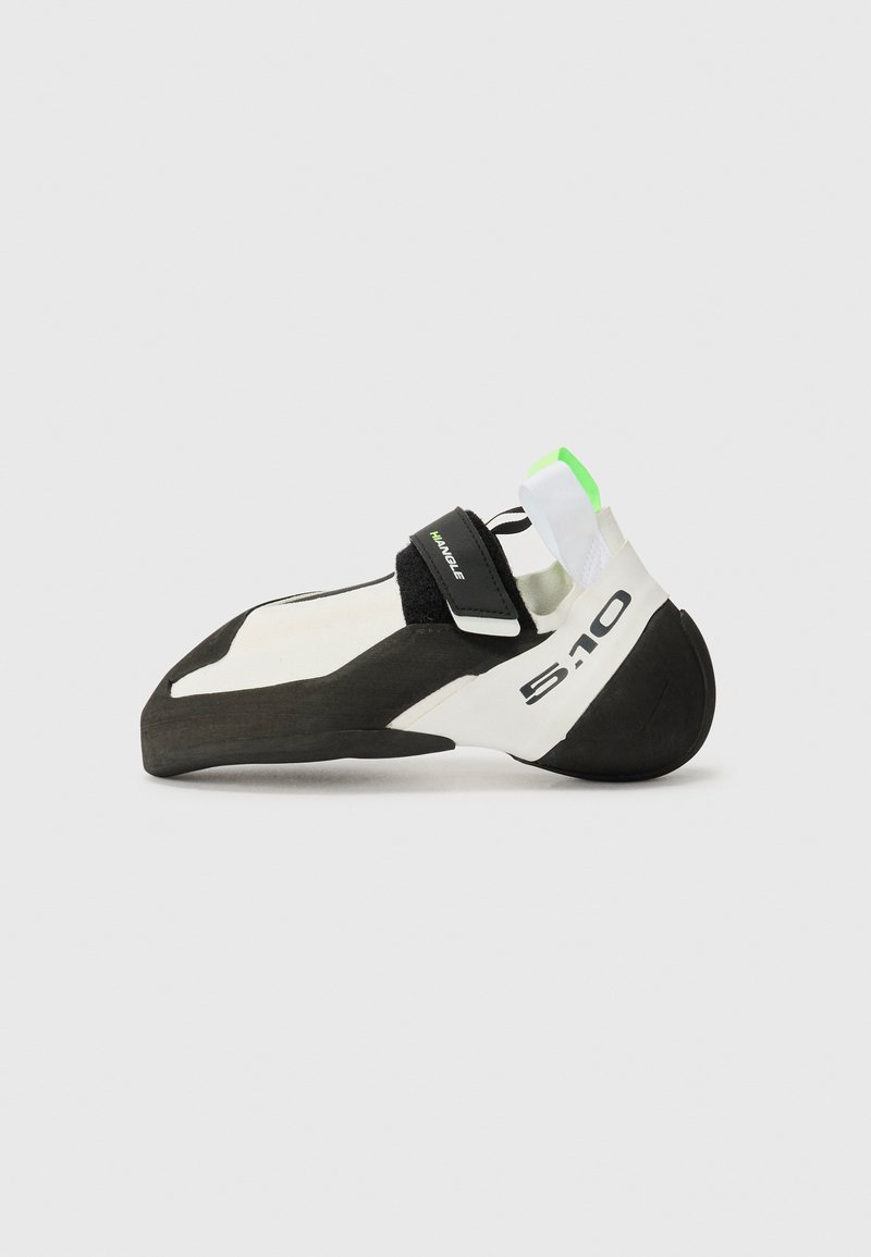 Climbing shoe in white and black with a green accent, featuring a pointed toe, velcro strap, and a rubber sole for grip.