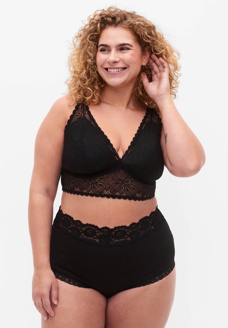 Zwarte kanten bralette met een diepe V-hals en golvende randen, gecombineerd met hoge zwarte onderbroek met kantafwerking.