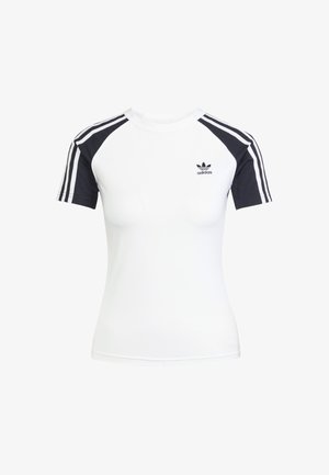 Bijela majica kratkih rukava s crnim raglan rukavima. Ima tri crne pruge na ramenima i mali crni Adidas logo na prsima.
