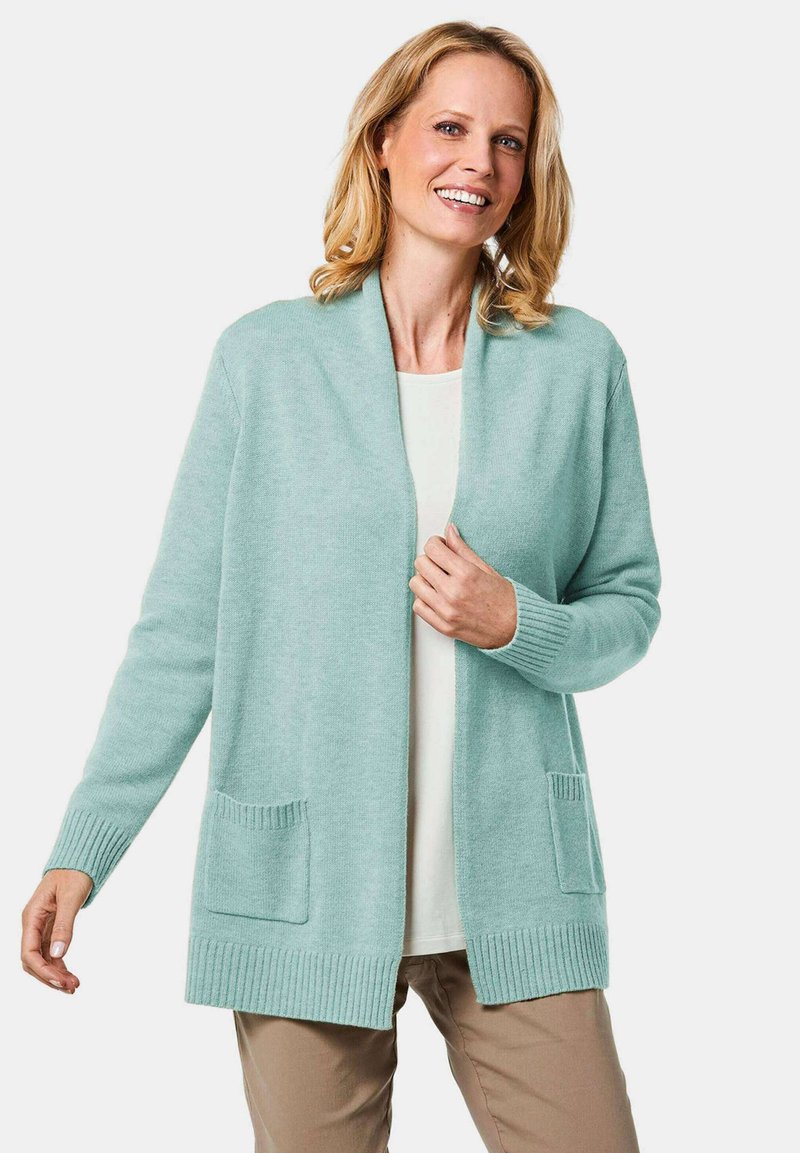 Hellblauer Cardigan mit Schalkragen, gerippten Bündchen und zwei Vordertaschen. Besitzt eine weiche Textur, ein offenes Vorderdesign und eine lässige Passform.