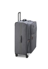 Grau farbener Stoffkoffer mit vier Spinner-Rädern, ausziehbarem Griff, seitlichen und vorderen Reißverschlusstaschen, aufrecht stehend vor weißem Hintergrund.
