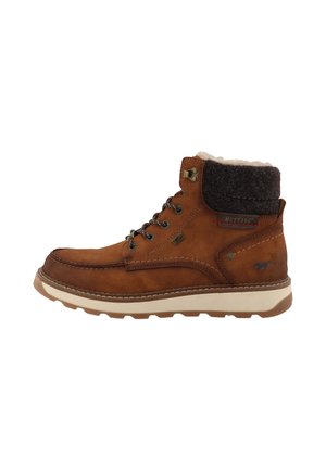 Bottine en cuir marron avec col rembourré noir, semelle beige, laçage à l’avant et logo Mustang apposé sur le côté et le talon.