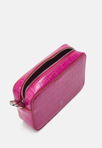 Pink faux-krokodille læderpung med rektangulær form, dobbelt lynlås i toppen og sølv hardware-detaljer. Tekstureret overflade med blank finish.