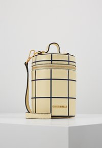 Borsa gialla rotonda in pelle testurizzata, con un motivo a griglia con linee navy, una cerniera dorata e una tracolla removibile.